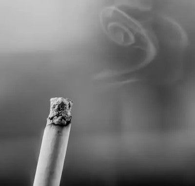 Une cigarette avec la fumée qui dessine une tête de mort